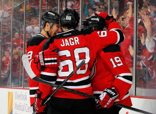 Travis Zajac #19 of the New Jersey Devils is congratulated by Dainius Zubrus #8 and Jaromir Jagr