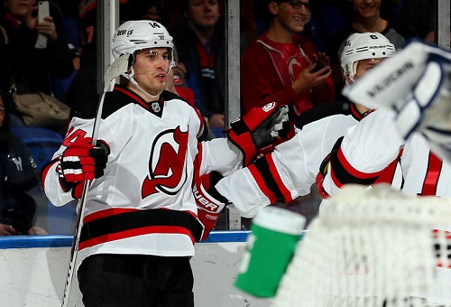 Adam Henrique #14 of the New Jersey Devils celebrates a first period goal against the New York Islanders during a game at the Nassau Veterans Memorial Coliseum on December 28, 2013 in Uniondale, New York. (Photo by Alex Trautwig/Getty Images)