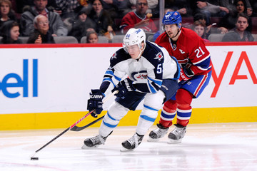 Mark Scheifele (#55) tries to protect the puck from Montreal Canadiens captain Brian Gionta (#21) during a game on February 2, 2014 at the Bell Centre in Montreal. (Getty Images)