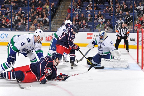 Jannik Hansen #36 of the Vancouver Canucks and Cam Atkinson #13 of the Columbus Blue Jackets battle for a loose puck in front of the net during the first period on March 12, 2013 at Nationwide Arena in Columbus, Ohio. (Photo by Jamie Sabau/NHLI via Getty Images)
