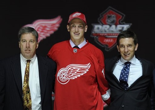 Anthony Mantha, a winger, stands with officials from the Detroit Red Wings sweater after being chosen 20th overall in the first round of the NHL hockey draft, Sunday, June 30, 2013, in Newark, N.J. (AP Photo/Bill Kostroun)