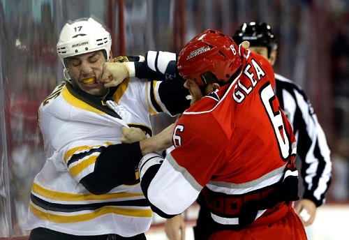 Carolina Hurricanes' Tim Gleason (6) hits Boston Bruins' Milan Lucic (17) while fighting during the first period of an NHL hockey game in Raleigh, N.C., Monday, Jan. 28, 2013. (AP Photo/Gerry Broome)