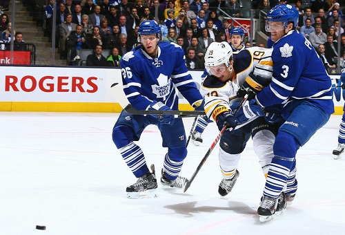 TORONTO , ON - JANUARY 15: Dion Phaneuf #3 of the Toronto Maple Leafs battles for the puck against Cody Hodgson #19 of the Buffalo Sabres during NHL game action January 15, 2014 at the Air Canada Centre in Toronto, Ontario, Canada. (Photo by Graig Abel/NHLI via Getty Images)
