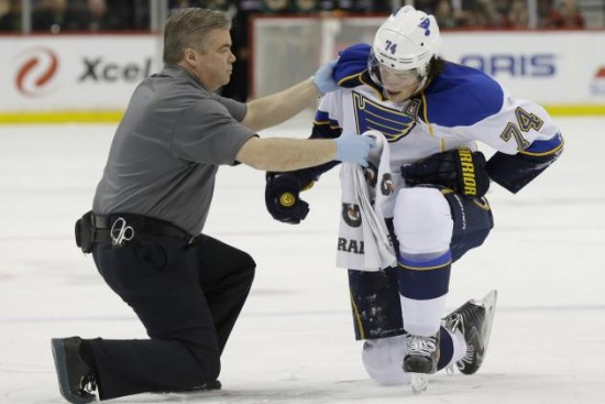 Blues forward T.J. Oshie is tended to by the team's trainer after receiving a dangerous hit from Minnesota Wild forward Mike Rupp. The effects of the hit kept Oshie out of the lineup on a day-to-day basis. (Photo by Ann Heisenfelt/AP)
