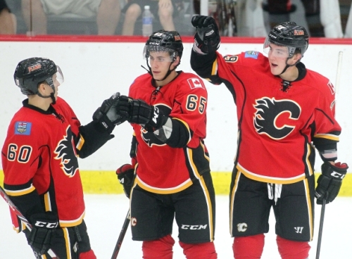 Flames forward Michael Ferland, right, celebrates with teammates Markus Granlund, left, and Turner Elson after scoring a goal against the University of Calgary Dinos in an exhibition game. (Photo by Ted Rhodes/Calgary Herald)