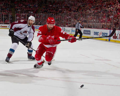 Detroit's Tomas Tatar races to get the puck before former Red Wings defenseman Brad Stuart. (Photo by Dave Reginek/NHLI via Getty Images)