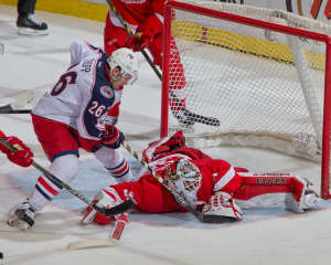 Detroit netminder Jimmy Howard makes a big save on Columbus's Corey Tropp late in the game December 16, 2014.  (Photo by Dave Reginek/NHLI via Getty Images)