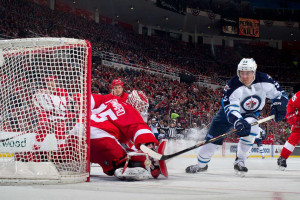 Jimmy Howard makes a save on Mark Scheifele in a game on Valentine's Day, 2015. (Photo by Dave Reginek/NHLI via Getty Images)