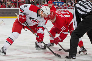 Carolina's Jay McClement and Detroit's Riley Sheahan anticipate the face-off. October 16, 2015. (Photo by Dave Reginek/NHLI via Getty Images)