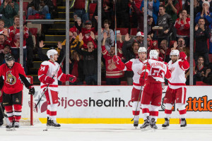 Gustav Nyquist (14), Justin Abdelkader (8) and Teemu Pulkkinen congratulate their captain, Henrik Zetterberg after his power play goal. October 30, 2015 in Detroit, Michigan. (Photo by Dave Reginek/NHLI via Getty Images)