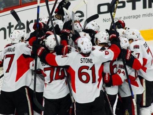 Ottawa Senators players celebrate after clinching a playoff spot with a win against the Philadelphia Flyers in the final game of the 2014/15 season. (AP Photo/Tom Mihalek)