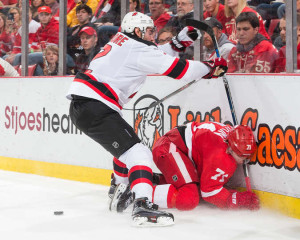 New Jersey's John Moore hits Detroit's Dylan Larkin in a game at Joe Louis Arena on December 22, 2015. (Photo by Dave Reginek/NHLI via Getty Images)