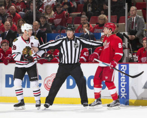Chicago captain Jonathan Toews and Red Wings forward Justin Abdelkader are policed by the linesman during a game at Joe Louis Arena on March 2, 2016. (Photo by Dave Reginek/NHLI via Getty Images)